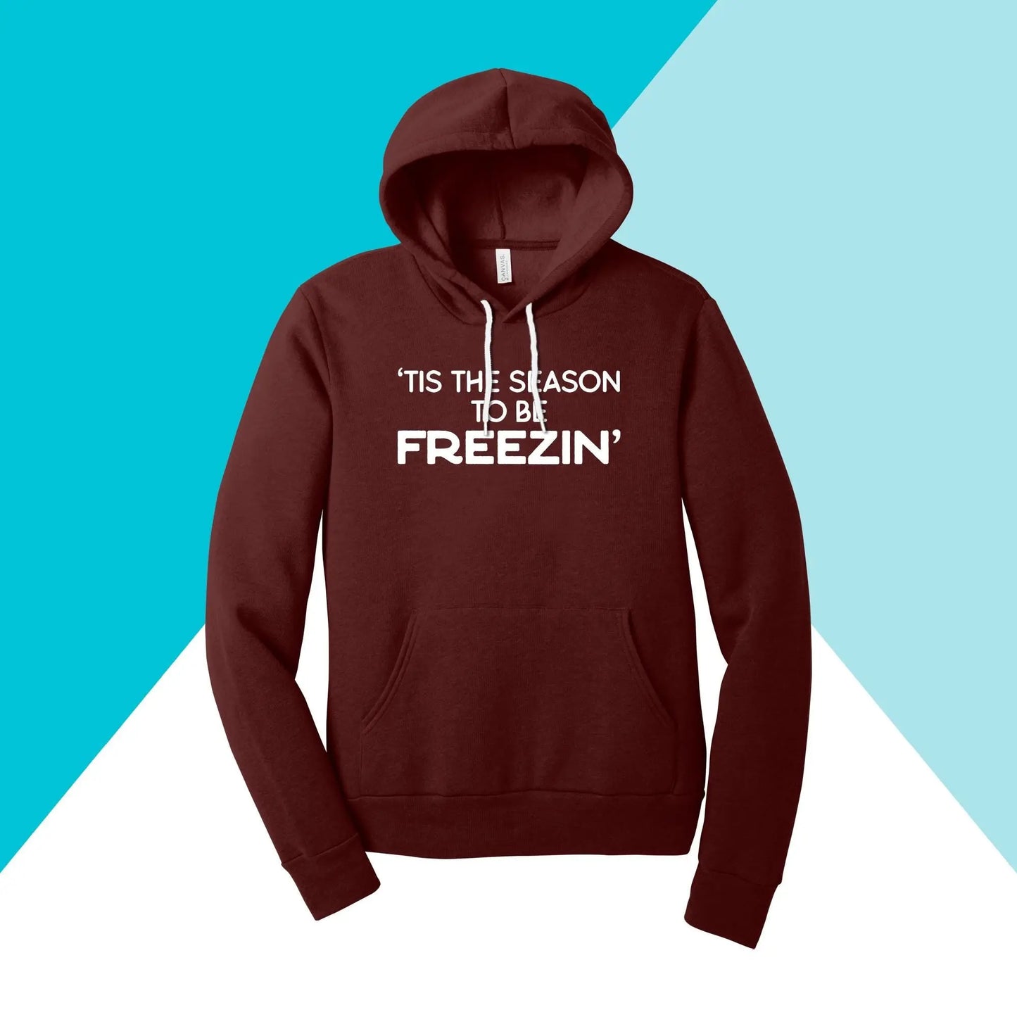 The North Owl Apparel unisex hoodie sweatshirt, Tis the Season to be Freezin, is showcased against a light blue and white triangular background, making it an ideal cozy maroon winter garment.