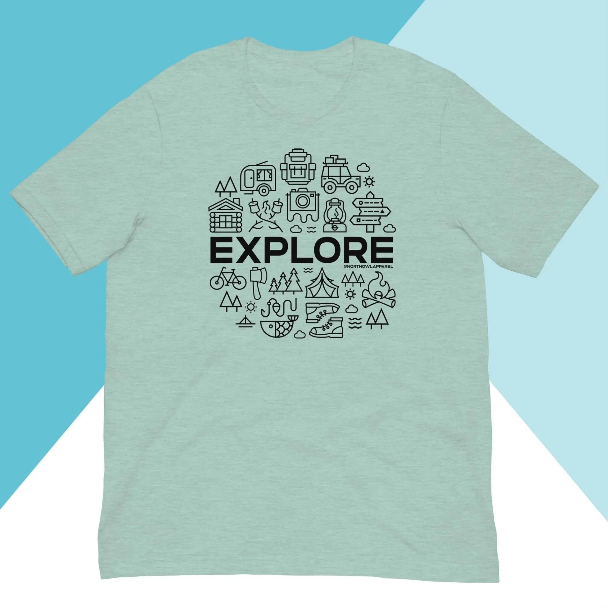 The Explore Outdoors Camping Unisex Shirt by North Owl Apparel is mint green with EXPLORE in bold black letters, surrounded by icons of a backpack, camera, compass, tent, and mountains. Designed for adventure and crafted sustainably against a blue and white geometric backdrop.